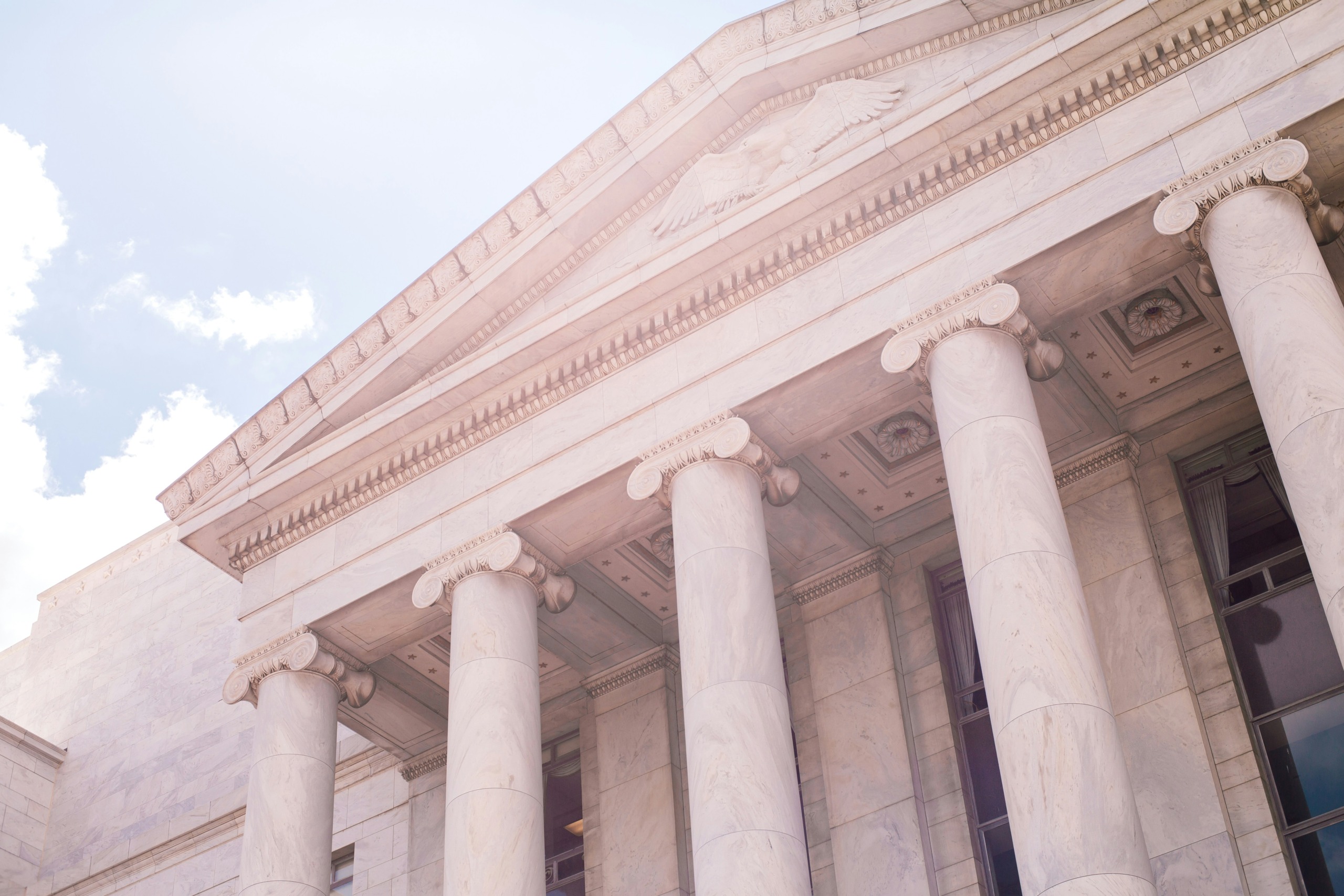 A from-the-ground view looking up at a pristine white government building.